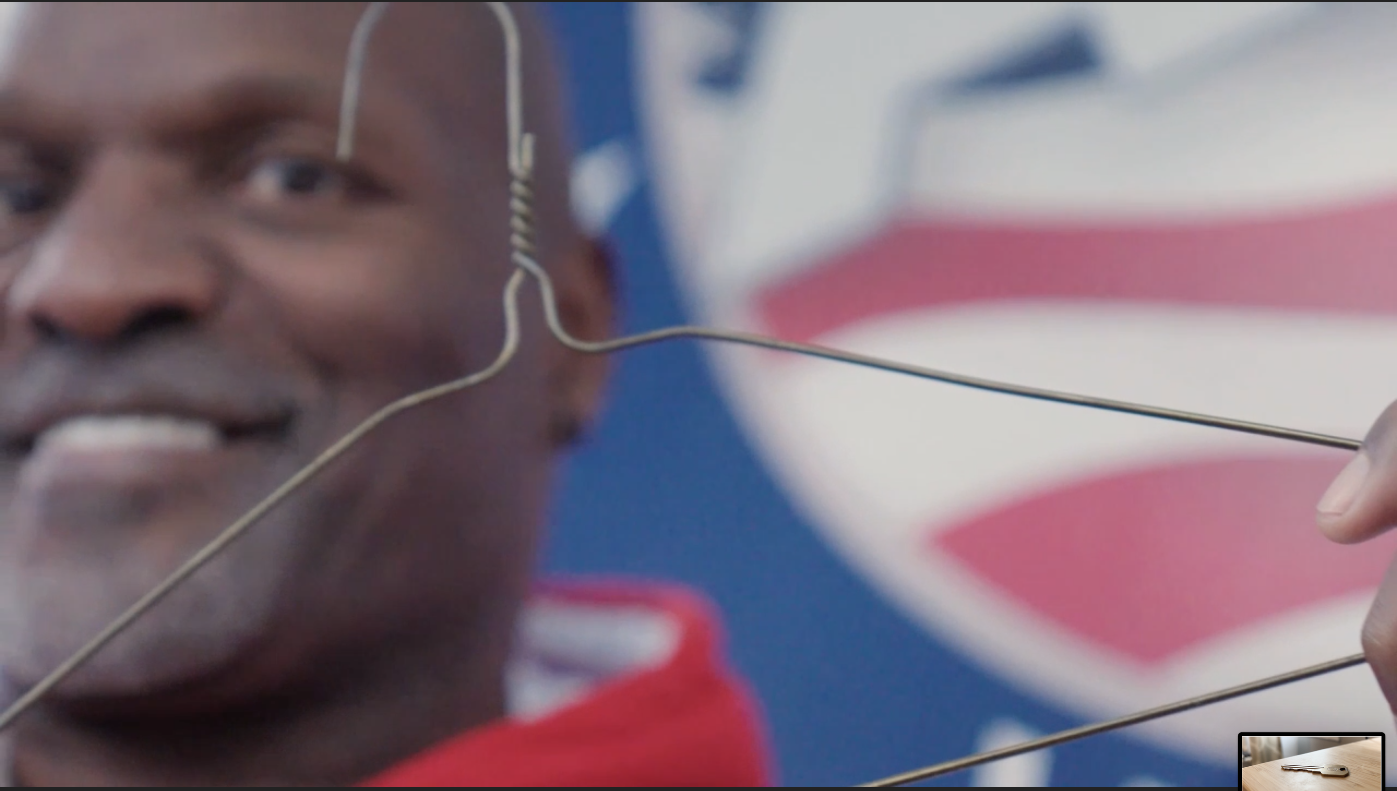 Ralpheal holding a wire hanger in front of the AHVets sign
